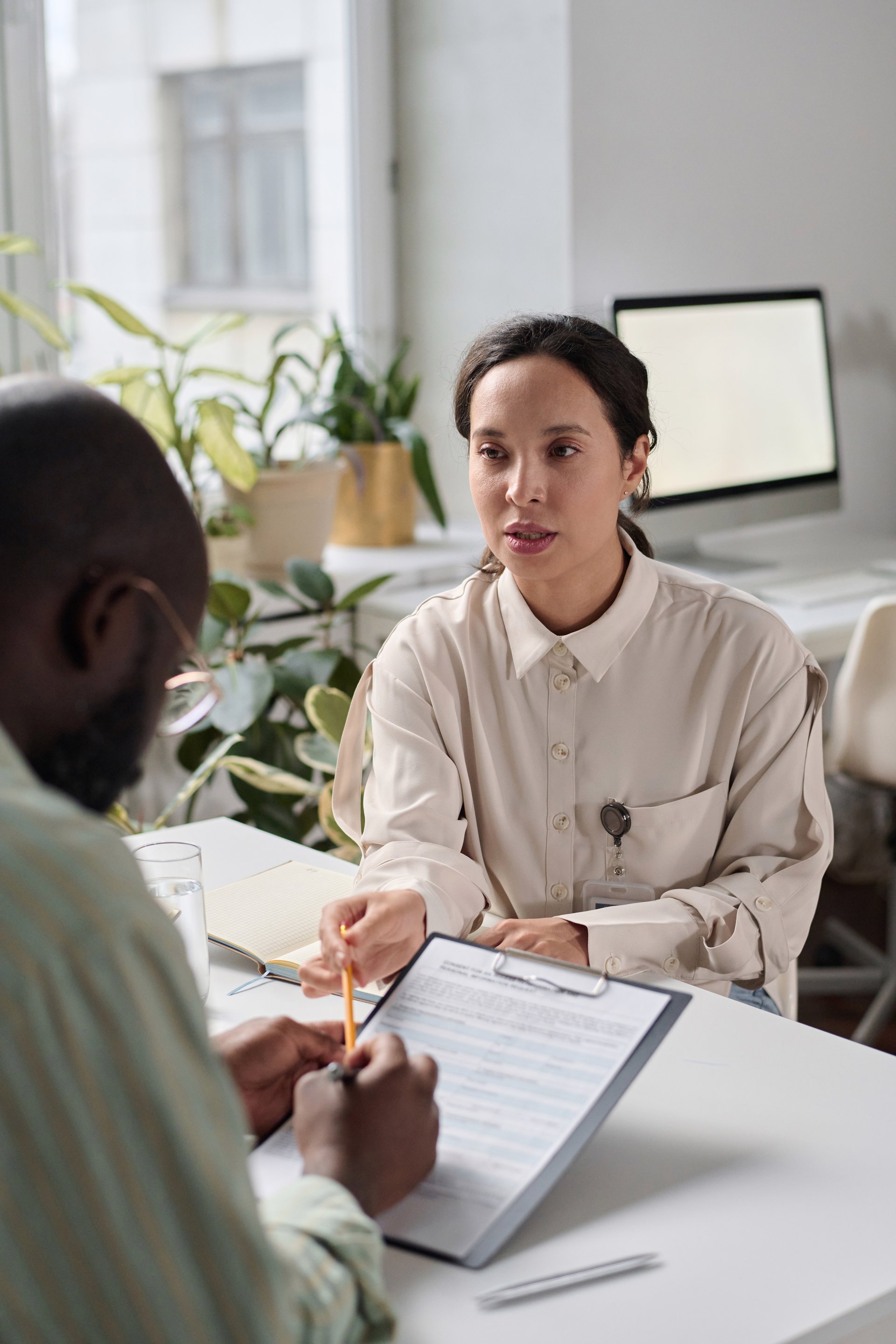 Professional advisor meeting with client to review documentation in bright office setting